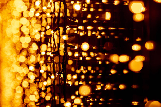 Abstrakter runder Bokeh-Hintergrund des Weihnachtslichts. Bokeh aus Girlanden. Hintergrund für Bildschirmschoner. Defokussiertes Licht. Verschwommenes Bokeh mit gelben Lichtern - Foto, Bild