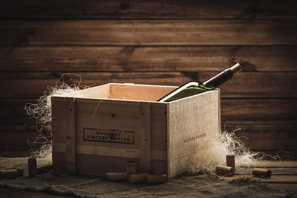 Бутылка вина в коробке в деревянном интерьере
  - Фото, изображение