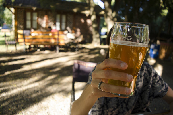 mão da mulher beber cerveja cerveja no jardim - Foto, Imagem