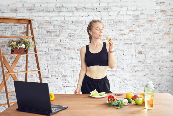 Sportive woman holding tasty apple. Concept of healthy organic and vitamin food. - Foto, Imagem