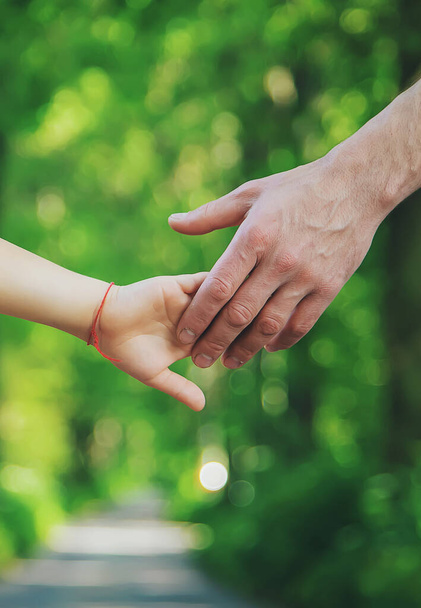 Apa és gyermek kéz a kézben járnak. Szelektív fókusz. természet. - Fotó, kép