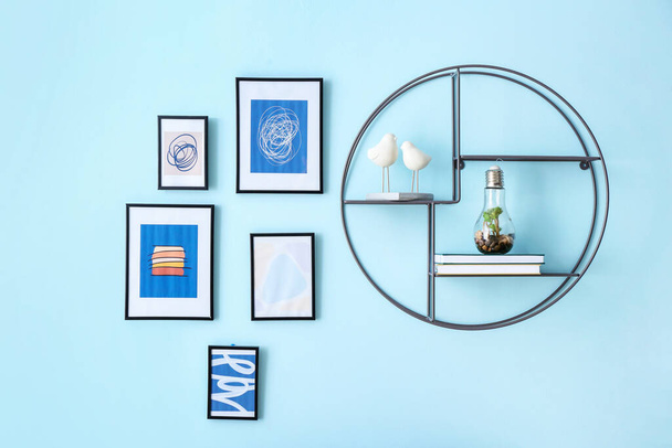 Stylish frames with pictures and shelf hanging on color wall - Photo, Image