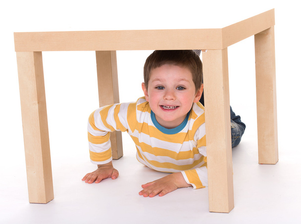 Little boy is sitting on the table. - Foto, Imagem