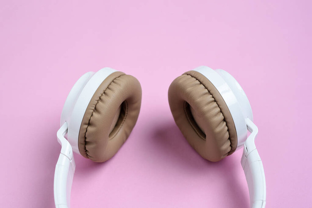 Close-up Cool słuchawki bezprzewodowe na różowym tle. Koncepcja muzyki - Zdjęcie, obraz