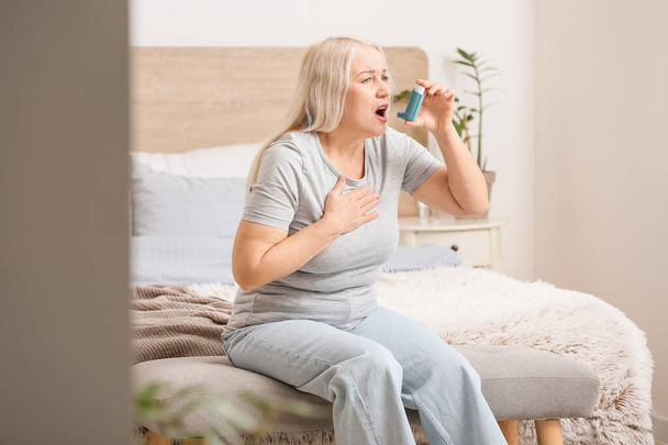Dojrzała kobieta z inhalatorem z atakiem astmy w domu - Zdjęcie, obraz