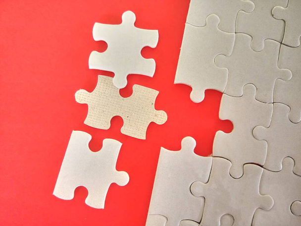 jigsaw puzzle pieces on the red background - Foto, Imagen