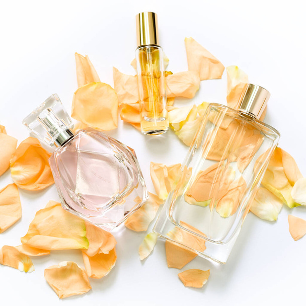 Perfume bottles with flower petals on light background. Perfumery, fragrance collection. Women accessories - Photo, Image