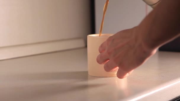 O processo de derramar café de uma cafeteira em uma xícara. Fluxo de café moído fresco. Beber café preto assado de manhã. Imagens de alta qualidade - Filmagem, Vídeo
