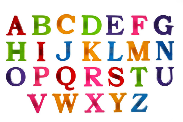 Kolorowe litery z tworzywa sztucznego, angielski alfabet na białym tle, izolat, widok z góry.  - Zdjęcie, obraz