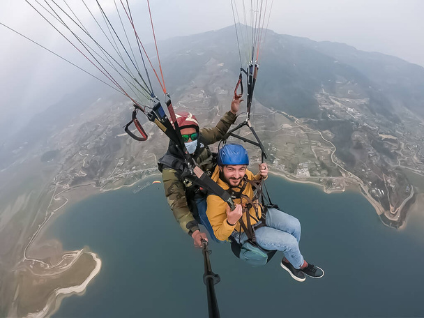 parapente nas montanhas, as duas pessoas no topo da montanha, os pára-quedistas estão voando com um paraquedas - Foto, Imagem