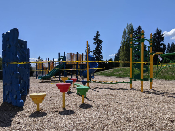 Blick auf einen abgeklebten bunten Spielplatz während der Coronavirus-Quarantäne in Washington an einem sonnigen Tag - Foto, Bild
