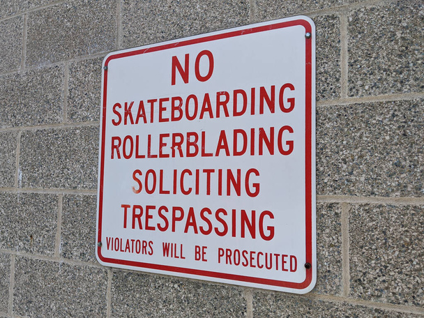 Angled view of a No Skateboarding and Rollerblading sign in a strip mall area - Photo, Image