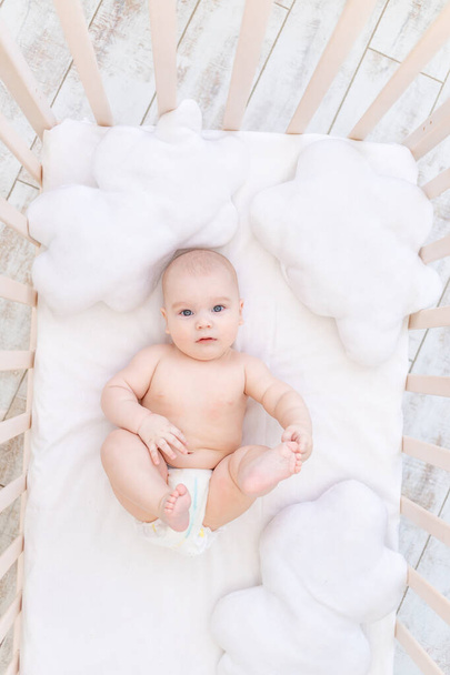 csecsemő fiú a bölcsőben a gyerekszobában, aranyos vicces baba hat hónap, egészséges alvás koncepció - Fotó, kép