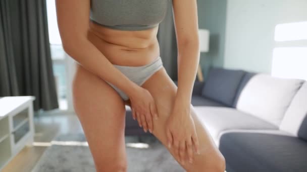 Woman smears her leg with anti-cellulite cream and does self-massage - Footage, Video