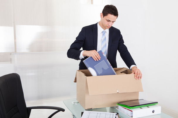 Businessman Packing Files In Cardboard Box In Office - Фото, изображение