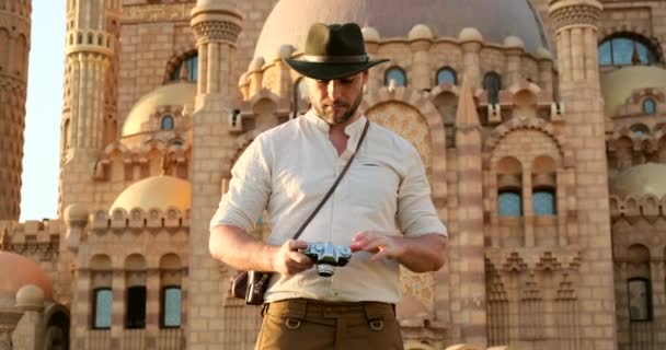 een toerist staat met een camera in de buurt van de moskee, minaret.archeology - Video