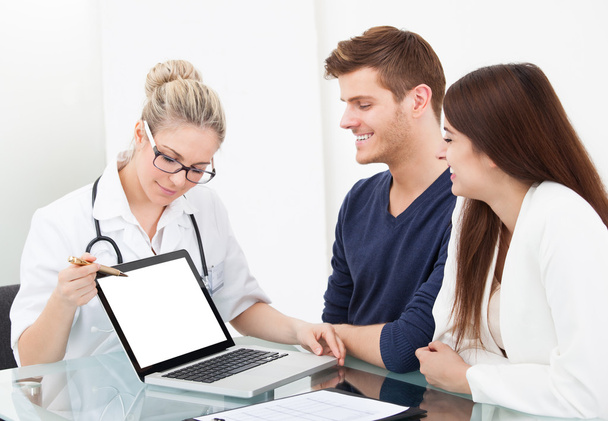 Doctor Showing Report To Couple On Laptop - Foto, Imagem