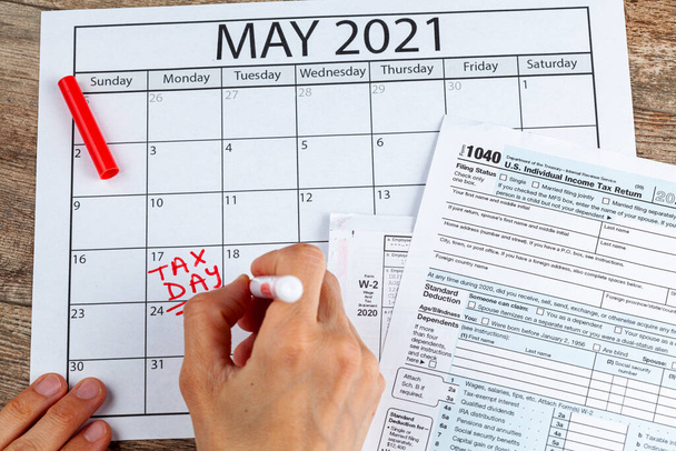 Η Υπηρεσία Εσωτερικών Εσόδων (IRS) έχει παρατείνει την προθεσμία για την υποβολή ομοσπονδιακού φόρου εισοδήματος των ΗΠΑ μέχρι τις 17 Μαΐου 2021. Αντίληψη εικόνας που δείχνει μια σελίδα ημερολογίου που σηματοδοτεί τη νέα φορολογική ημέρα για το 2021. - Φωτογραφία, εικόνα