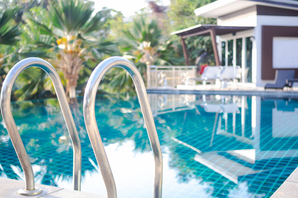 Fermer échelle de piscine avec de l'eau bleue et station bleuie. vacances de voyage touristique en vacances d'été concept. - Photo, image