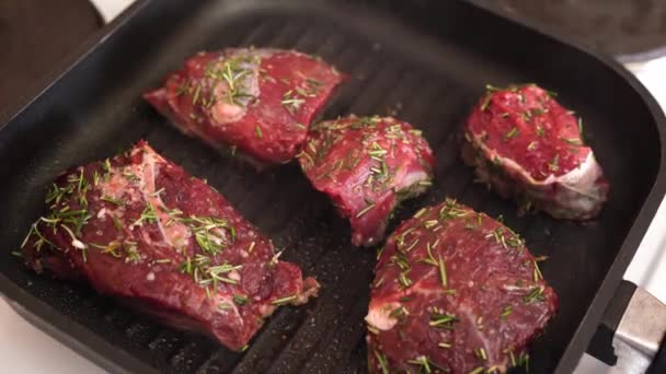 Een geurige mooie biefstuk wordt gebakken in een pan op een warme temperatuur. - Video