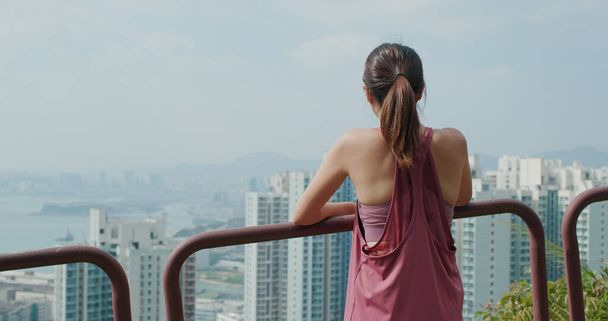 Γυναίκα κοιτάζει τη θέα της πόλης από το βουνό - Φωτογραφία, εικόνα