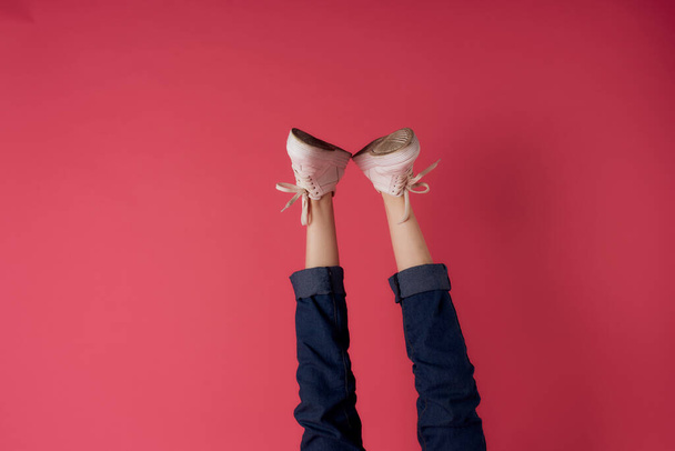 White sneakers upside down legs movement street fashion pink background - Photo, Image