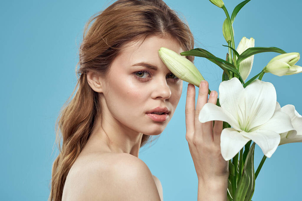 Lány egy csokor fehér virágok egy kék háttér piros haj portré modell - Fotó, kép