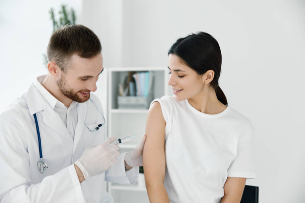doctor giving a shot to a woman in the shoulder vaccination epidemic hospital - Fotografie, Obrázek
