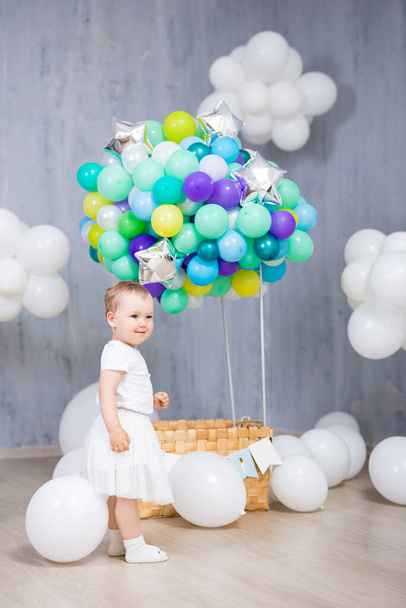 usmívající se holčička s barevnými vzduchovými balónky a bílými mraky - Fotografie, Obrázek