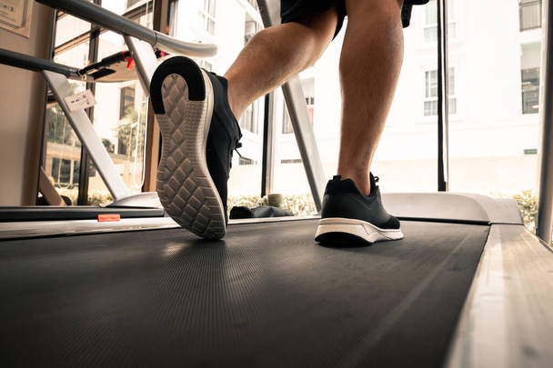 Man legs with sport shoes running on treadmill in fitness gym. - Photo, Image