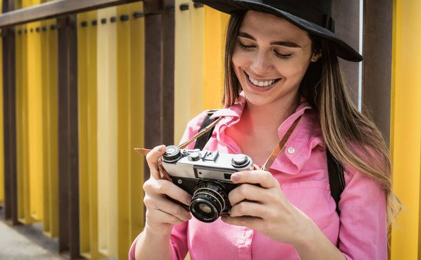 Молодая женщина во время отпуска фотографирует со старой винтажной камерой - Фото, изображение