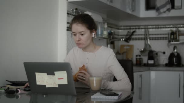 Vrouw eet haar ontbijt tijdens werken op afstand thuis - Video