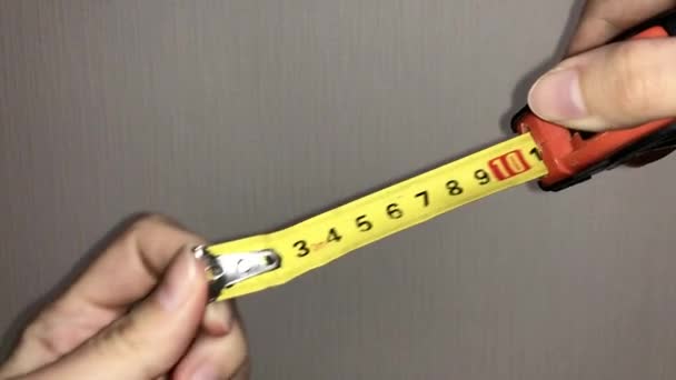 Mujer estirando cinta amarilla medida con números. de cerca. - Metraje, vídeo