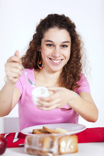 Young beautiful woman eating her morning yogurt - Fotoğraf, Görsel