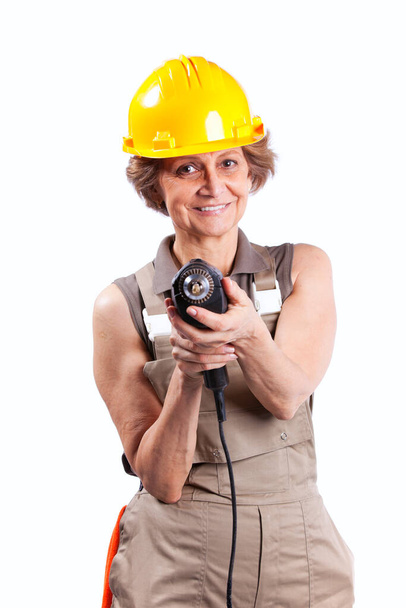 Happy senior woman holding a drill tool (isolated on white) - Valokuva, kuva