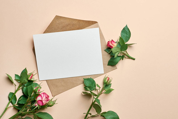 Blank greeting card mockup with fresh roses bouquet on paper background - Foto, imagen