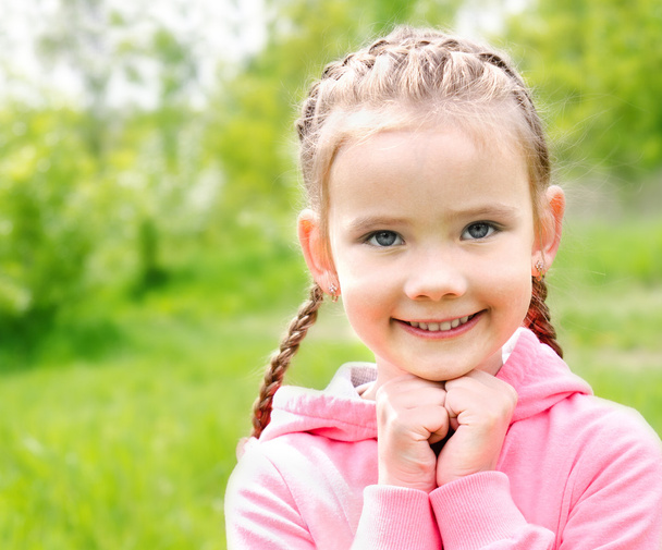 Portrait of adorable smiling little girl on the meadow - Фото, изображение