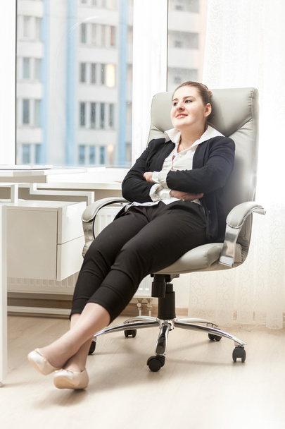 businesswoman relaxing in leather chair at office - Photo, Image