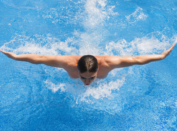 Athletic man swimming in pool butterfly style - Photo, Image
