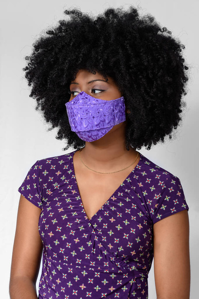 tiener meisje dragen gezichtsbescherming masker tegen covid-19 geïsoleerd op grijze achtergrond - Foto, afbeelding