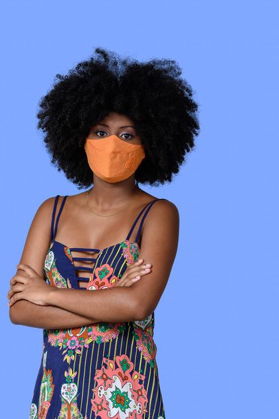 adolescente chica usando máscara de protección facial contra covid-19 aislado sobre fondo azul - Foto, Imagen