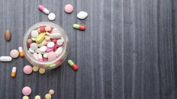 bovenaanzicht van vele kleurrijke pillen en capsules morsen op tafel  - Video