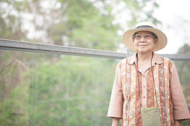 vieille femme âgée voyageuse âgée voyageant sur la passerelle dans le parc. mode de vie de loisirs senior - Photo, image