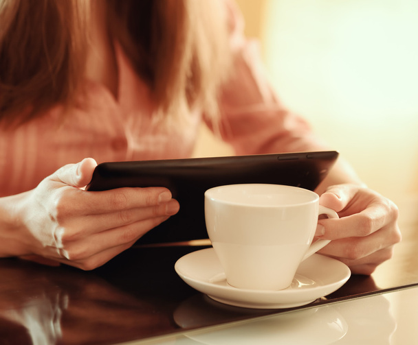 Young woman using tablet computer in cafe - Foto, Bild