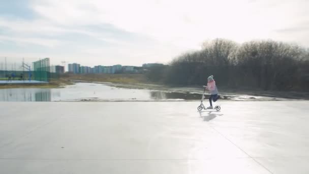 Девушка на скутере на детской площадке - Кадры, видео
