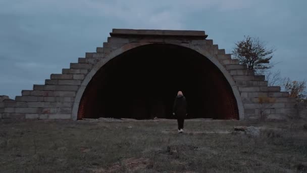 Osamělá blondýna dívka kráčí do ztraceného zničeného hangáru na podzim. - Záběry, video
