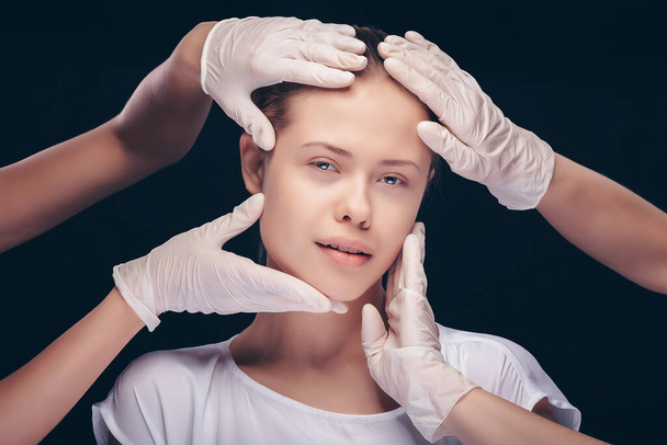 Young woman with eyes closed having an medical exam of her face skin by plastic doctors - Fotografie, Obrázek