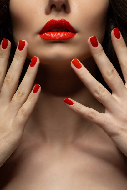Beautiful girl showing red manicure nails . makeup and cosmetics. Brunette girl with long and shiny curly hair - Φωτογραφία, εικόνα