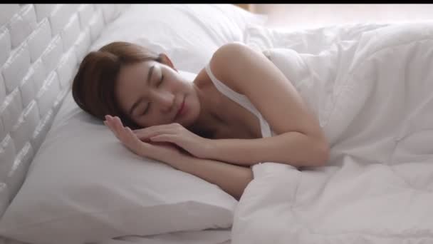 Aziatische vrouwen slapen en zoete droom op wit bed in de slaapkamer - Video