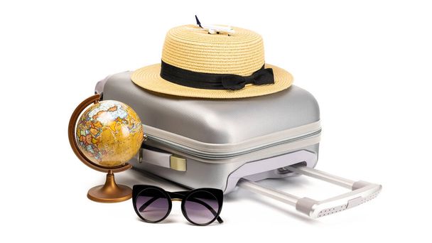 バッグ旅行だ。スーツケース、白い背景に隔離された旅行組成物中のおもちゃの飛行機、わらの帽子と地球を持つサングラス。夏休みのコピースペースとビジネス旅行のコンセプト - 写真・画像